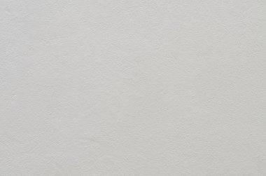 Açık gri bir duvarın yumuşak ve düzensiz dokusu, geniş bir yelpazede minimalist ya da ürün odaklı kompozisyonlar için mükemmel bir arkaplan oluşturur..