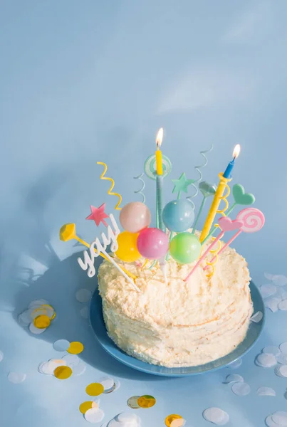Birthday cake with candles and decor on blue background. Smash cake.
