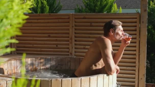 Man Relaxing Wooden Hot Tub Outdoor Guy Drinks Herbal Tea — Stok video