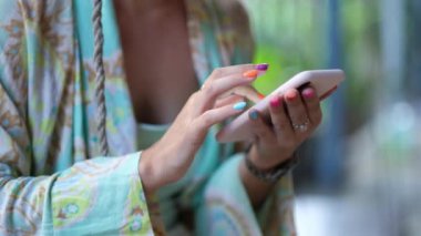 Modern fashionable young woman with colorful nail polish checks social networks on mobile phone. 4k footage 