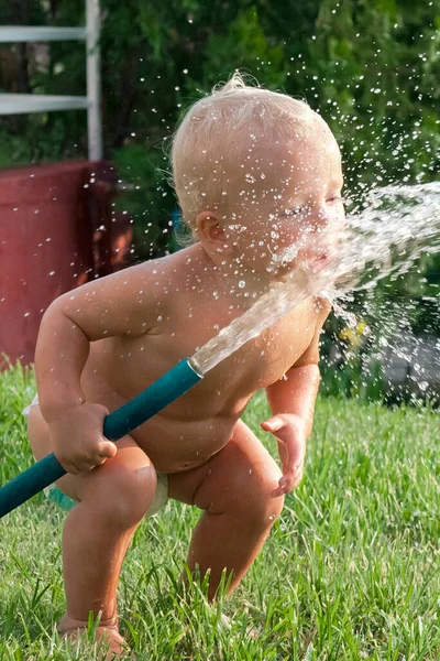 夏に屋外のウォーターホースで遊んでいる子供の幼児の少年 夏の活動 高品質の写真 — ストック写真