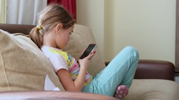 Cute Little Girl Using Technology Device Sitting Sofa Girl Playing — Stockvideo