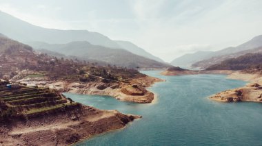 Güzel bir kanyon ve turkuaz tatlı suyla dolu bir nehir manzarası. Doğa yolculuğu geçmişi. Dimchay Nehri 'nde kuş bakışı bir baraj..