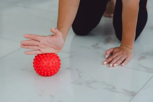 Woman hands pressing on small ball to relieve pain in arms, massage small muscles and pain in hand, perform exercises to relieve pain in muscle and joints. Relaxation and stretching of muscles.