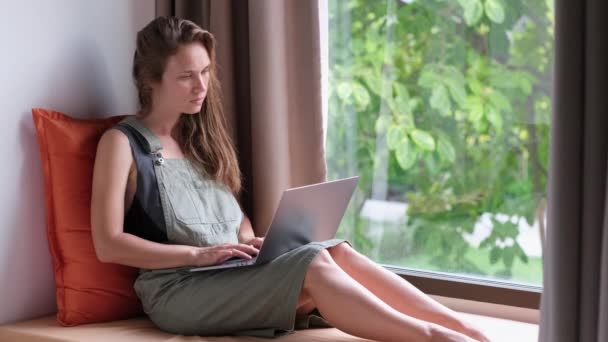 Jovem Mulher Sentada Peitoril Janela Usando Laptopand Computador Está Nervoso — Vídeo de Stock