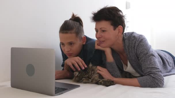 母亲和十几岁的儿子一起在电脑笔记本电脑上看电影 家庭周末 — 图库视频影像