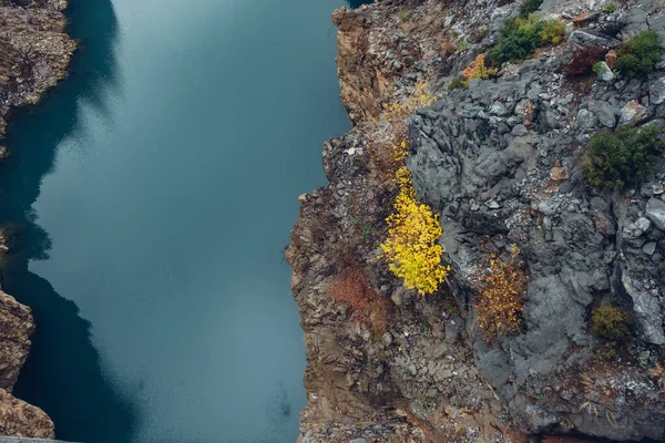 岩場の間の静かなターコイズブルーの山の川の表面の垂直空中ビュー — ストック写真