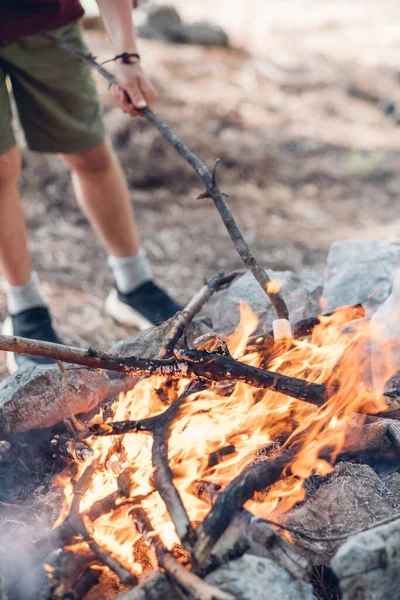 stock image Child roasting marshmallows on stick at bonfire. Kid having fun at camp fire and cooking dessert. Treat for kids on camping.