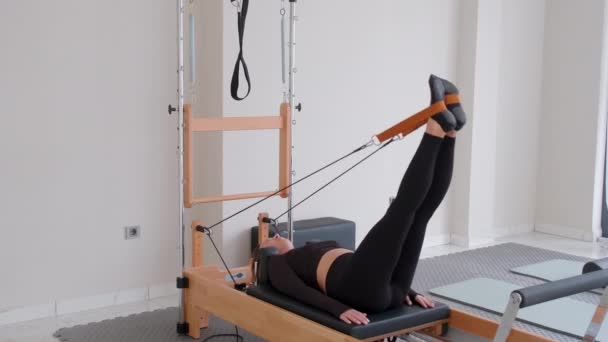 Woman Wearing Black Sportswear Practicing Pilates Exercises Reformer Machine Studio — Stock Video