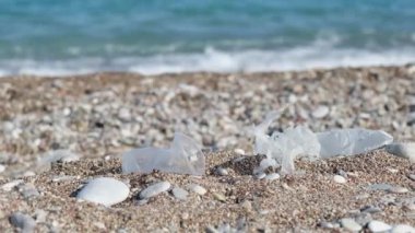 Kumsaldaki plastik çöpler. Doğa kirliliği kavramı. Sahil şeridinde tek kullanımlık plastik..