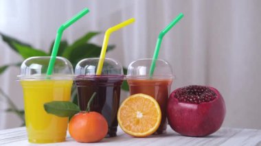 Fresh juices. Assortment of colored fruit juices to take away in a plastic glass. 