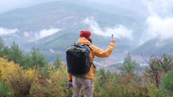 大自然徒步旅行的游客用手机拍摄山水风景 英俊的雄性河马在秋天的大自然中漫步 凉爽的天气 — 图库视频影像