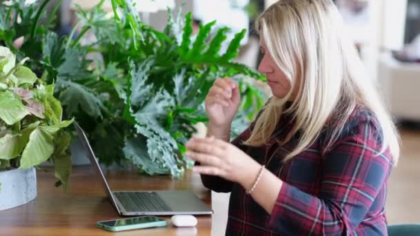 中年ブロンド女性作業ノートパソコンながら座ってカフェ室内 — ストック動画
