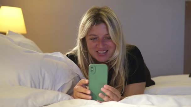 Sarışın Bir Kadın Gece Yatmadan Önce Akıllı Telefonuyla Evde Mesaj — Stok video