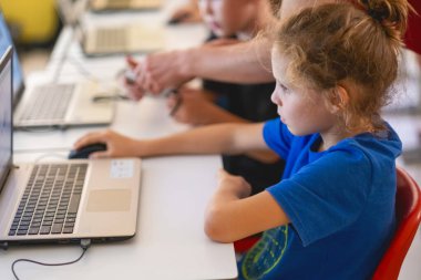 Bilgisayar bilimi dersi sırasında okul çocuğu dijital kodlama programı öğreniyor..