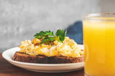 Beyaz tabakta maydanozlu yumurta, tahtadan yapılmış ev yapımı sağlıklı kahvaltı..