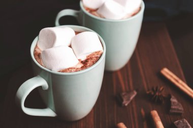 Sıcak çikolatalı içecek, içinde lokum olan tahta bir bardak, koyu arka plan..