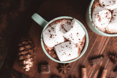 Sıcak çikolatalı içecek, içinde lokum olan tahta bir bardak, koyu arka plan..