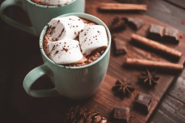 Sıcak çikolatalı içecek, içinde lokum olan tahta bir bardak, koyu arka plan..