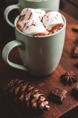 Sıcak çikolatalı içecek, içinde lokum olan tahta bir bardak, koyu arka plan..