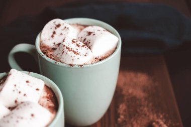 Sıcak çikolatalı içecek, içinde lokum olan tahta bir bardak, koyu arka plan..