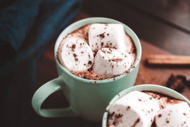 Sıcak çikolatalı içecek, içinde lokum olan tahta bir bardak, koyu arka plan..