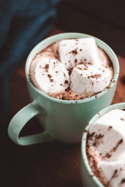 Sıcak çikolatalı içecek, içinde lokum olan tahta bir bardak, koyu arka plan..