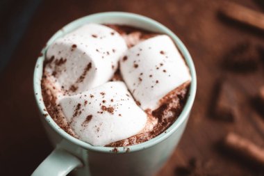 Sıcak çikolatalı içecek, içinde lokum olan tahta bir bardak, koyu arka plan..