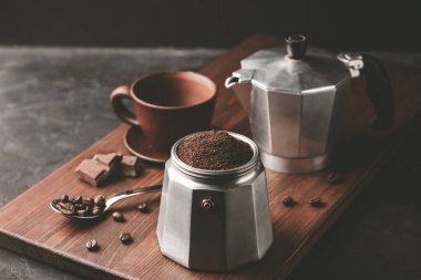 Kahverengi kahveyle doldurulmuş kahve demliği koyu ahşap tahtada, İtalyan espresso demlemeye hazır olun..