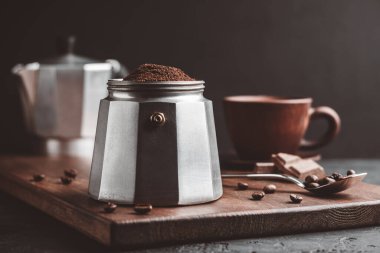 Kahverengi kahveyle doldurulmuş kahve demliği koyu ahşap tahtada, İtalyan espresso demlemeye hazır olun..