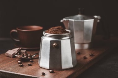 Kahverengi kahveyle doldurulmuş kahve demliği koyu ahşap tahtada, İtalyan espresso demlemeye hazır olun..