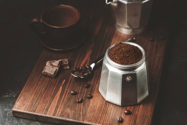 Kahverengi kahveyle doldurulmuş kahve demliği koyu ahşap tahtada, İtalyan espresso demlemeye hazır olun..