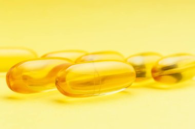 Sarı Omega-3 kapsülleri, yağ asidi, besin takviyesi hapları..