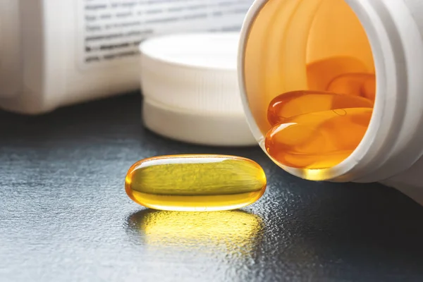 Yellow capsule of omega 3 fatty acid, supplement pills.