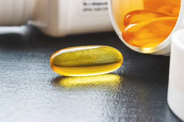 Yellow capsule of omega 3 fatty acid, supplement pills.