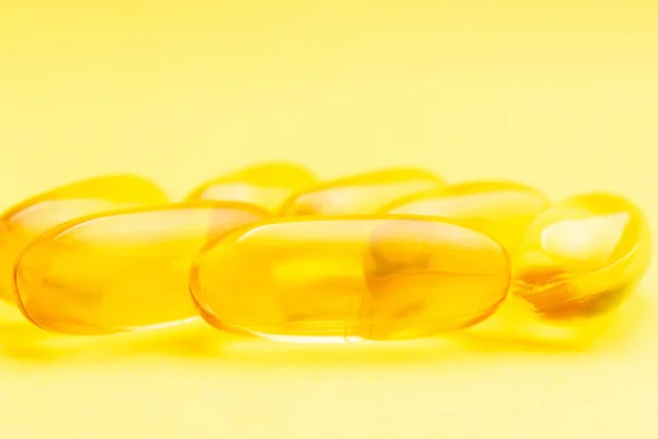 Yellow capsules of omega-3, fatty acid, nutritional supplement pills.