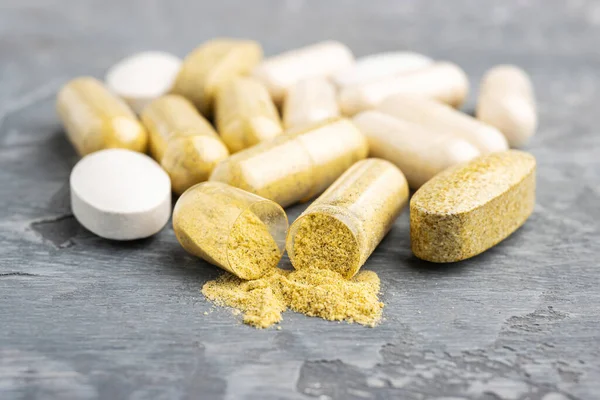 Mix of herbal supplement capsules and vitamin pills.