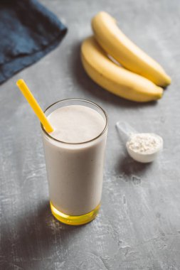 Banana smoothie with protein powder in a glass, healthy eating concept.