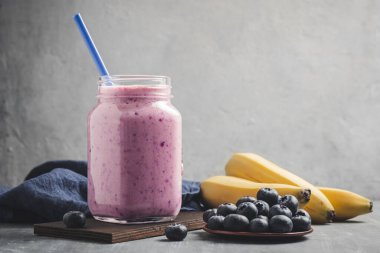 Blueberry and banana smoothie drink in a glass jar, healthy eating concept.