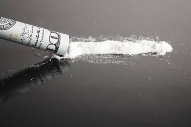 Kokain çekmek, beyaz toz hattı, dolar banknotları, siyah arka plan..