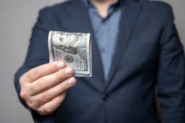 İyi giyimli bir adam elinde tutuyor ya da bir tomar para, dolar banknotları, Amerikan kağıt paraları veriyor..