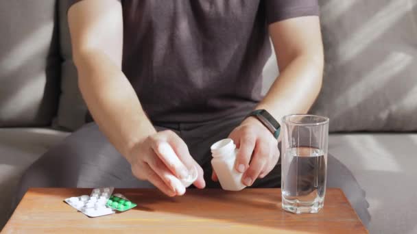 Чоловік Сидить Вдома Дивані Приймає Ліки Таблетки Або Вітамінні Капсули — стокове відео