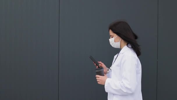 Молода Жінка Лікар Медичній Масці Білому Пальто Стетоскопом Використовує Смартфон — стокове відео