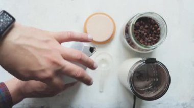 Erkek elleri gayzer kahve makinesiyle, kahve demleme süreci, üst manzara, yavaş çekim.