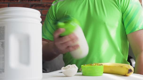 Неузнаваемый Человек Зеленой Спортивной Рубашке Встряхивающий Протеиновый Энергетический Напиток Процесс — стоковое видео