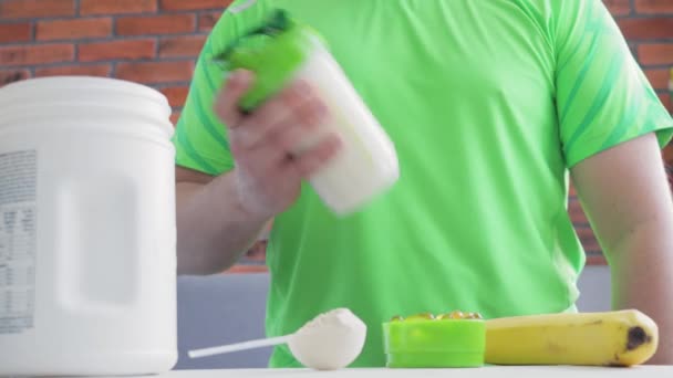 Неузнаваемый Человек Зеленой Спортивной Рубашке Встряхивающий Протеиновый Энергетический Напиток Процесс — стоковое видео