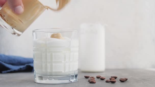 アイス ダルゴナ コーヒー 生コーヒーと砂糖をミルク入りのガラスに加えるスプーン付きの男性用手の製造プロセス — ストック動画