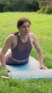 Genç çekici, sportif bir kadın dışarıda yoga yapıyor. Sabah köpek pozu veriyor. Sağlıklı yaşam tarzı kavramı.