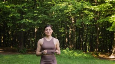 Yaz parkında dışarı koşan çekici bir kadın, sabah ormanda koşan bir kadın, ağır çekim. Sağlıklı yaşam tarzı kavramı