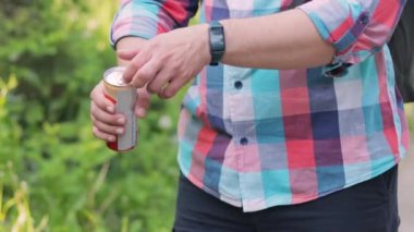 Erkek el, dışarıda soda, limonata ya da enerji içeceği ile alüminyum kutu açıyor.